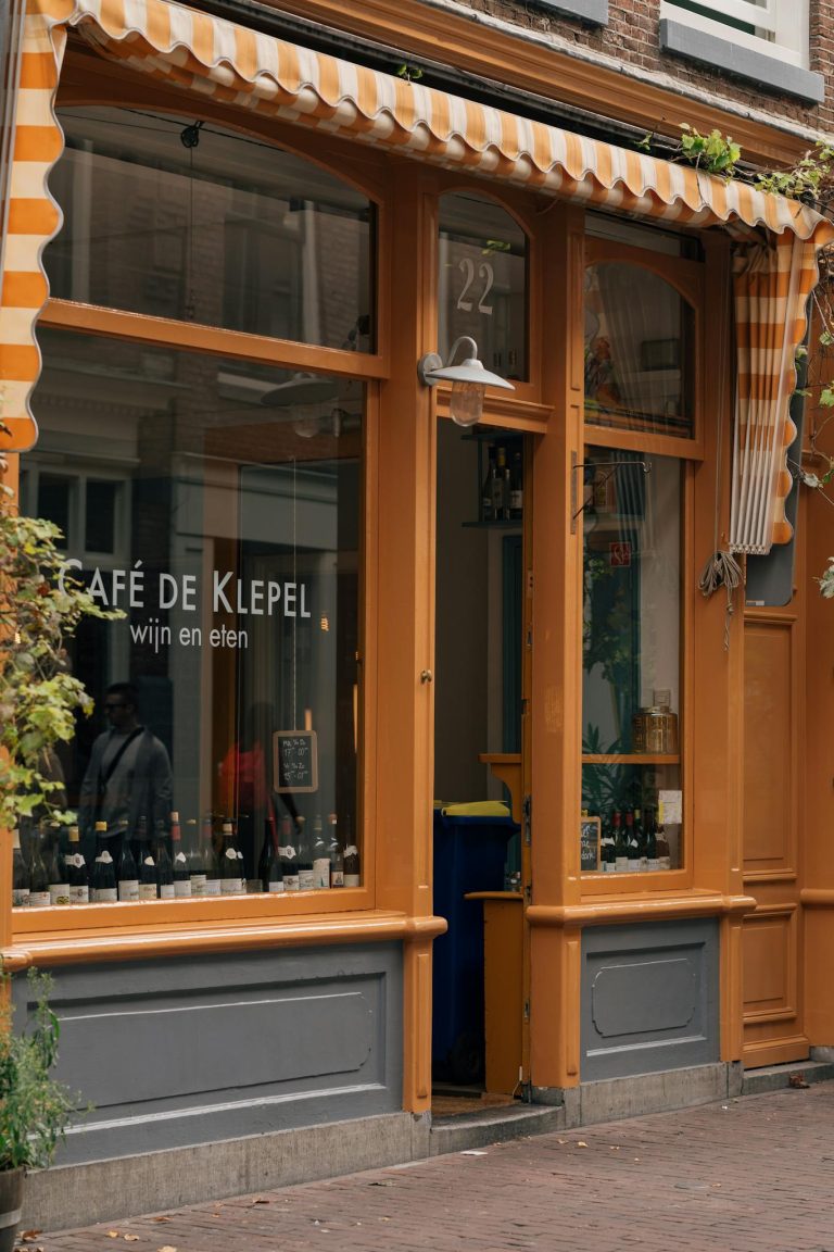 Exterior view of a quaint café in Amsterdam, featuring classic architecture and inviting vibes.